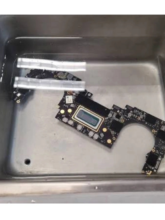 MacBook logic board in ultrasonic bath of high-purity isopropyl alcohol in Dubai — MacTech Pro
